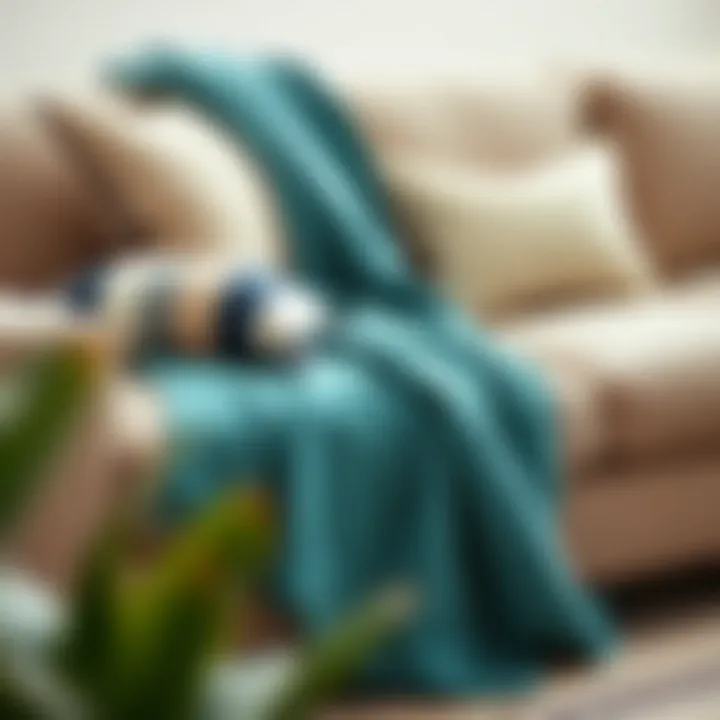 Teal throw blanket accenting a neutral sofa with decorative pillows
